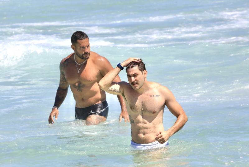 Ex-BBB Caio Afiune e Bill Araújo se refresca na praia da Barra Da Tijuca