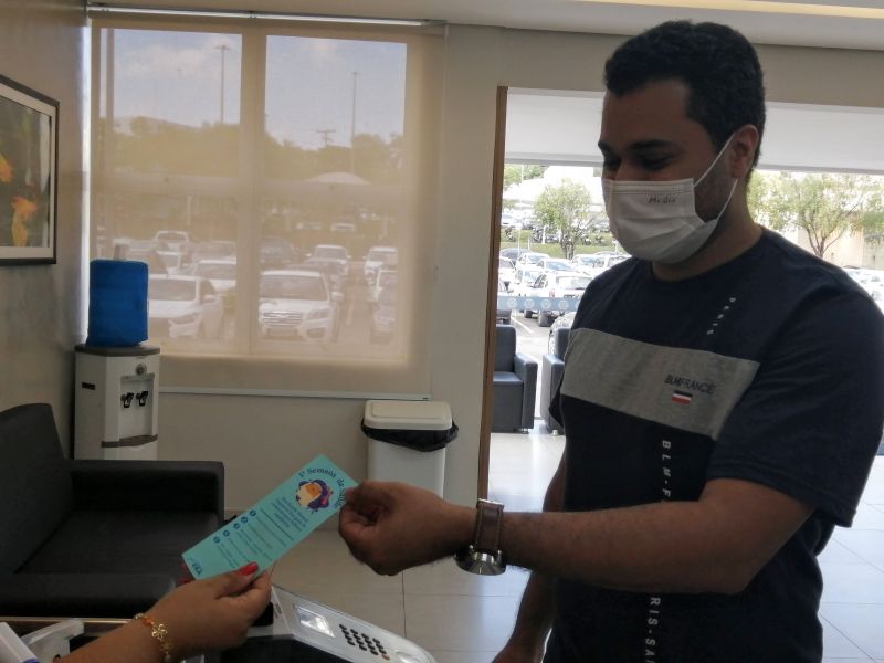 Na entrada, o servidores recebem um marcador de livros falando da semana da saúde - Foto por: Adilson Rosa Seduc MT