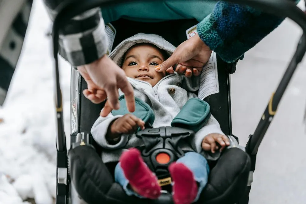 Foto de William Fortunato : https://www.pexels.com/pt-br/foto/bebe-em-cinza-e-vermelho-com-capuz-no-carrinho-6393239/