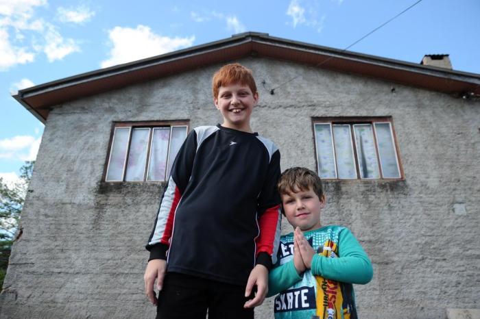 Léo, 11 anos, e o irmão Eduardo, quatro, na frente da casa nova da família no bairro Panorâmico Antonio Valiente / Agencia RBS