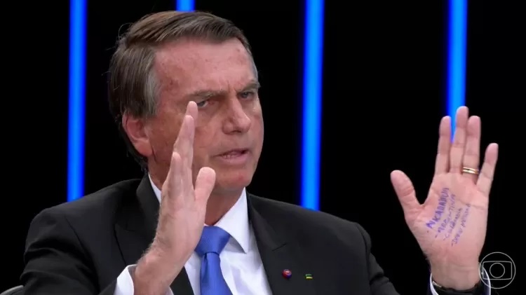 A 'cola' na mão de Jair Bolsonaro no 'JN' Imagem: Reprodução/TV Globo