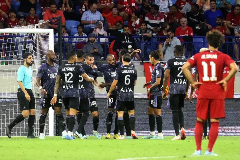 Jogadores do Lyon comemoram gol de Lacazette, enquanto Salah, do Liverpool, lamenta — Foto: AFP